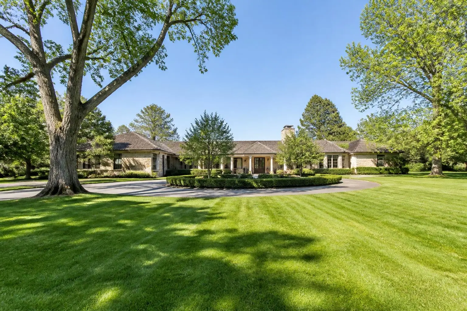 A stone terrace overlooking a wooded lawn at a Charlotte estate home